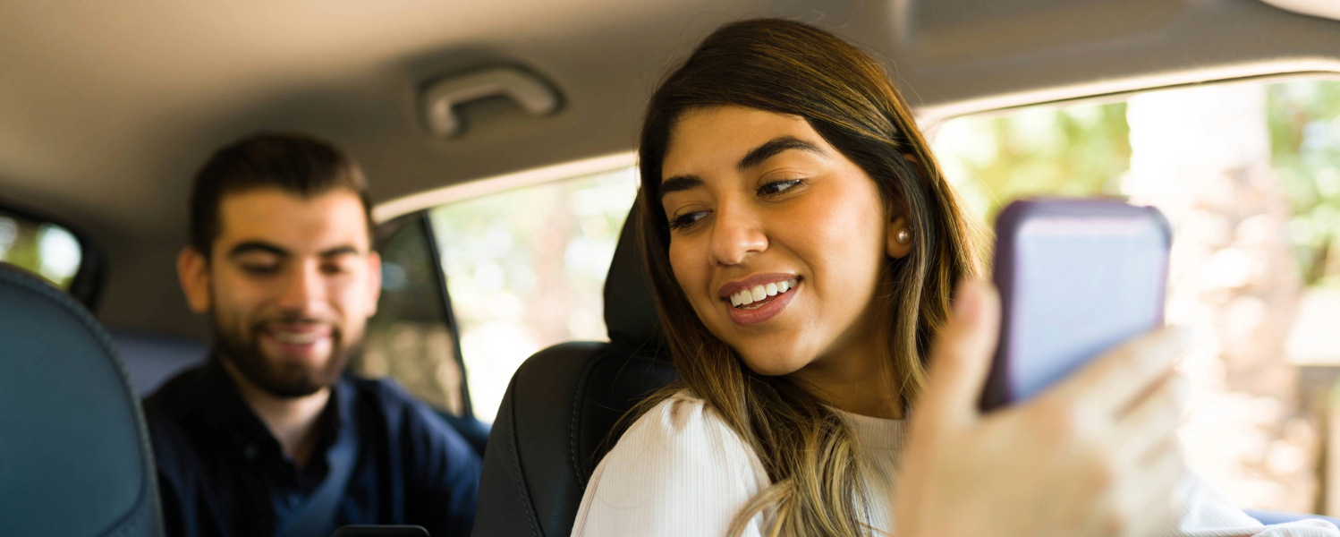 driver on her phone talking to rider in the back